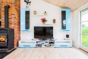 a living room with a television and a fireplace at Coastal Hideout Vacation Home in Bøtø By