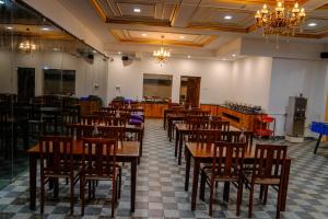 a dining room with wooden tables and chairs at Luxe Vista Resort Kodai in Kodaikānāl