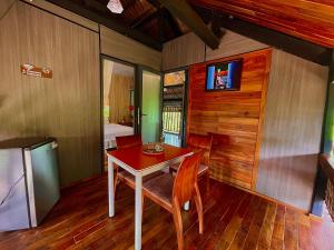 a dining room with a table and a tv on the wall at Lam Mountain Retreat Ông Lang in Phú Quốc