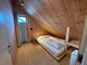 a bedroom with a bed in a wooden room at Malnestomten in Henningsvær