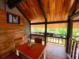 a dining room with a red table and a window at Lam Mountain Retreat Ông Lang in Phú Quốc