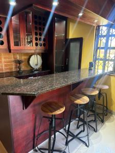 a kitchen with bar stools at a counter at The Cozy Corner House in Durban