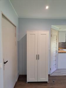 a white cabinet in a room with a door at Amber in Ragaciems