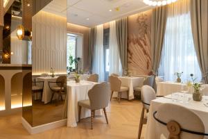 a dining room with white tables and chairs at Heritage Hotel Zagreb Dubrovnik in Dubrovnik