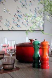 a table with wine glasses and colorful vases on it at Het Plategoed in Oosthoek