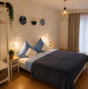 a bedroom with a large bed with blue pillows at Apartments Alma in Pag