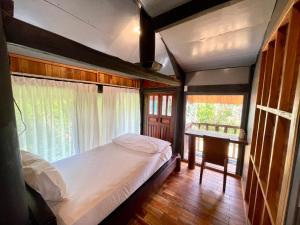 a bedroom with a bed and a window at Lam Mountain Retreat Ông Lang in Phú Quốc