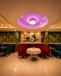 a purple ceiling in a restaurant with a table and chairs at Surya Regency in Kāshīpur
