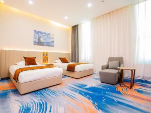 a hotel room with two beds and a chair at Zenn Hotel Erdenet in Erdenet +17 photos