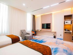 a hotel room with two beds and a television at Zenn Hotel Erdenet in Erdenet