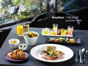a table with plates of food and drinks on it at Hotel Intergate Osaka Umeda in Osaka