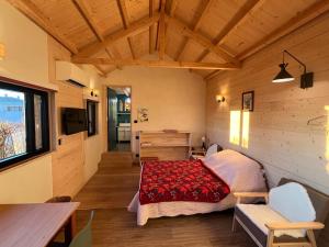 a room with a bed and a desk and a table at La Cabane - Studio à la campagne avec Clim - Annecy 15 min in Marcellaz-Albanais