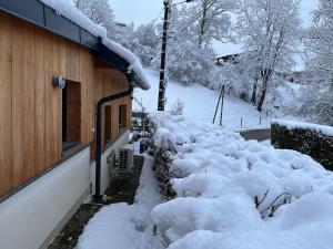 a pile of snow on the side of a house at La Cabane - Studio à la campagne avec Clim - Annecy 15 min in Marcellaz-Albanais +3 photos
