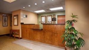 a waiting room with a reception desk and a potted plant at Best Western Plus Edison Inn in Garner