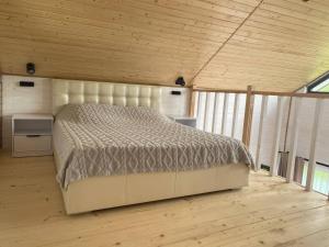 a large bed in a room with a wooden ceiling at Rose & Raspberry Garden in Shevchenkovo
