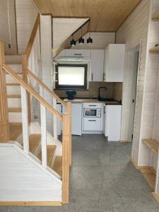 a kitchen with white cabinets and a staircase in a house at Rose & Raspberry Garden in Shevchenkovo
