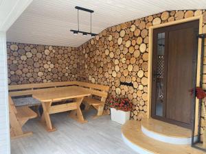 a room with a wooden table and a wall of logs at Rose & Raspberry Garden in Shevchenkovo