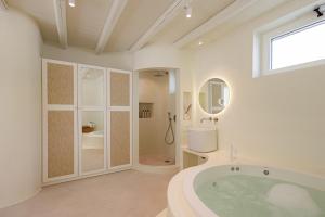 a large bathroom with a tub and a shower at Naxia Gaia Suites in Agia Anna Naxos +66 photos
