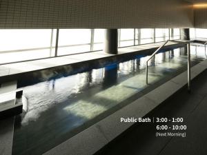 a swimming pool in a building with people in it at Hotel Intergate Osaka Umeda in Osaka