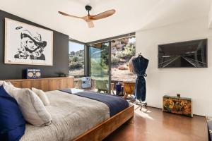 a bedroom with a bed and a ceiling fan at Mod West Ranch: 5-acre Boulder Playground in Pioneertown