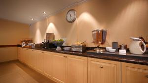 a kitchen with a counter with a clock on the wall at Best Western Tumwater-Olympia Inn in Tumwater
