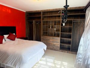 a bedroom with a bed and a red wall at The Cozy Corner House in Durban +18 photos