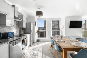 a kitchen with a wooden table and blue chairs at Henry's Apartment on Commercial Street in Dundee