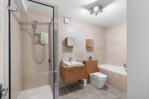 a bathroom with a shower and a toilet and a sink at Henry's Apartment on Commercial Street in Dundee +31 photos