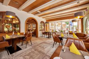 a restaurant with wooden ceilings and tables and chairs at Landhotel Böld Oberammergau in Oberammergau