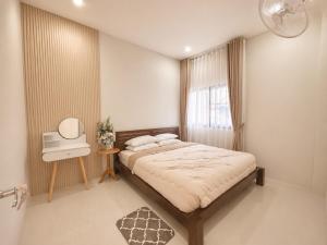 a bedroom with a bed and a window at Kulanat House in Chiang Mai