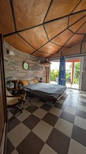 a bedroom with a bed and a checkered floor at La Rond'Dada in Sainte-Suzanne