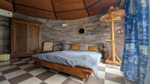 a bedroom with a bed in a stone wall at La Rond'Dada in Sainte-Suzanne