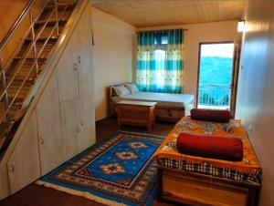a small room with a bed and a staircase at Denzongpa Homestay in Takdāh