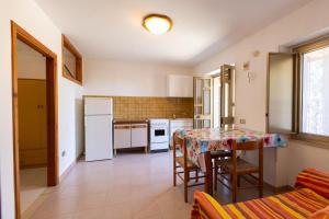 a kitchen with a table and a table and chairs at Agriturismo Millepini in Peschici