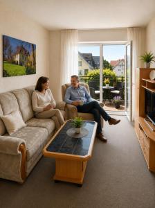 a couple of people sitting in a living room at Gästehaus Stillecke in Erwitte
