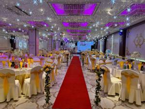 a banquet hall with white tables and chairs and a red carpet at Zenn Hotel Erdenet in Erdenet