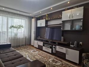 a living room with a couch and a flat screen tv at Three Rooms Comfort in Chişinău
