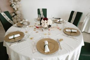 a table with a white table cloth and plates and glasses at Kento Resort Hotel in Centuripe