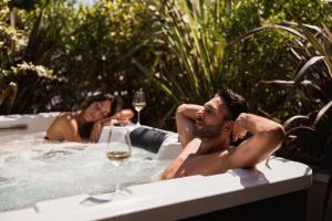two people in a hot tub with a glass of wine at Hotel Sporting Riccione in Riccione