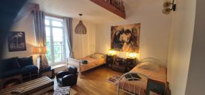 a small room with two beds and a window at Manoir des Nobles Cœurs et Spa in Saint-Donan