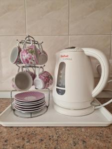 a tea kettle and plates on a tray at Three Rooms Comfort in Chişinău