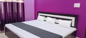 a bedroom with a large bed with purple walls at Saraswati Sadan Homestay Ayodhya in Faizābād +17 photos