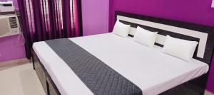 a bedroom with a large bed with purple walls at Saraswati Sadan Homestay Ayodhya in Faizābād