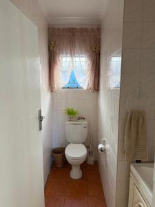 a bathroom with a toilet and a window at Sweet Willa Bed and Breakfast in Roodepoort +15 photos