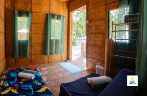 a small room with a bed and a window at Point Calixto beach front hut, Boracay in Boracay