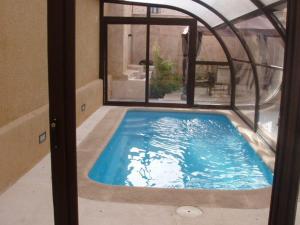 a swimming pool in a house with a window at Casa Rural Descanso del Quijote in Belmonte