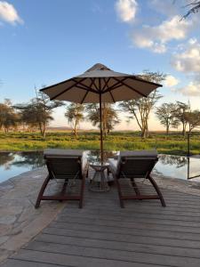 a table and two chairs under an umbrella at Soroi Amboseli in Amboseli