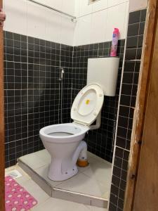 a bathroom with a toilet with a black tiled wall at Nairobi Transit Lounge in Nairobi +29 photos
