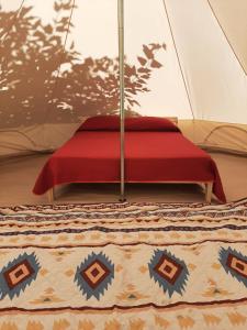 a bed in a tent with a red blanket at Glamping Agricampeggio Tognoni in La Sdriscia +33 photos