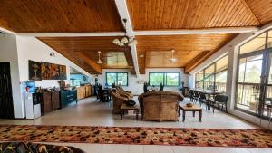 an open living room with wooden ceilings and a dining room at Roc Heights in Bakau